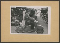 Fotografie: Junger Mann auf stehendem Motorroller